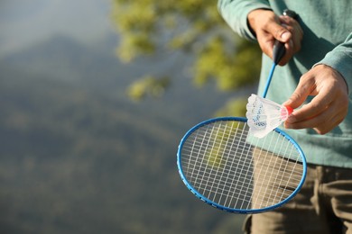 Photo of Man playing badminton outdoors on sunny day, closeup. Space for text