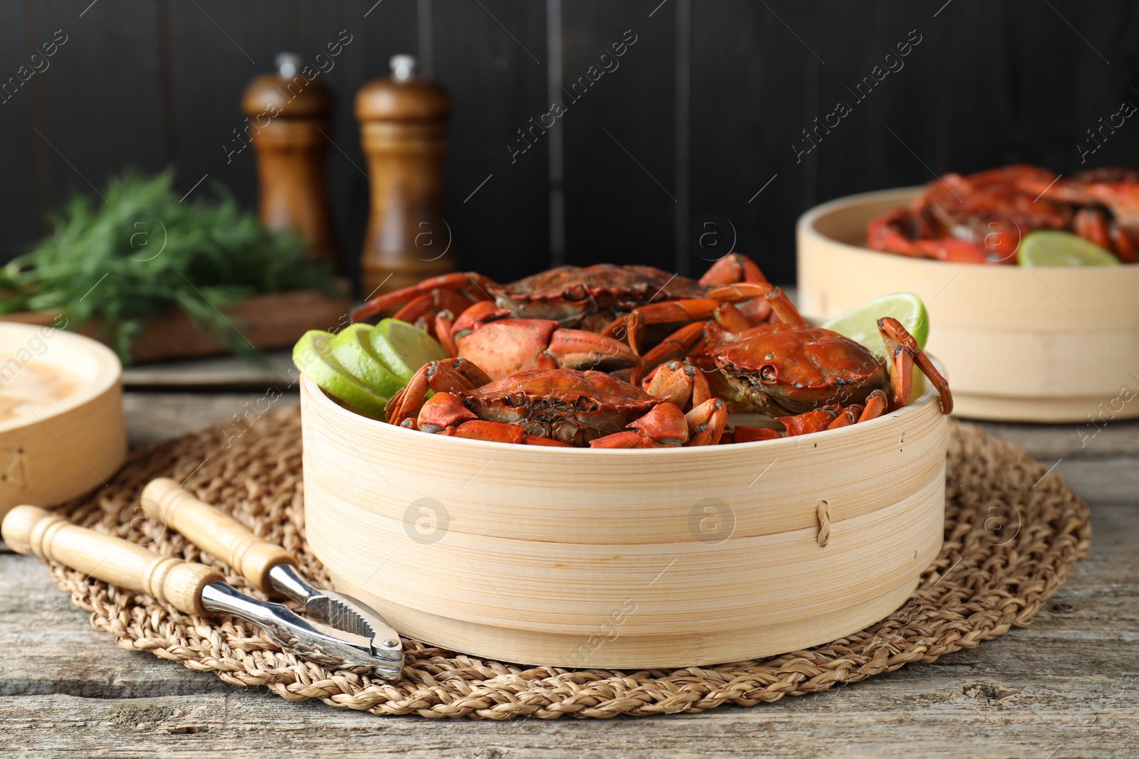 Photo of Delicious boiled crabs with lime and dill served on wooden table