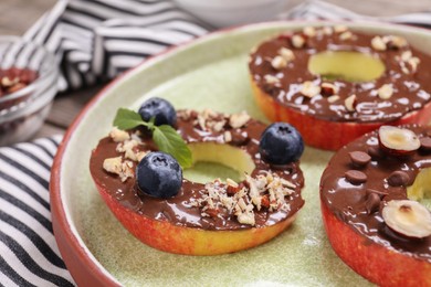Photo of Fresh apples with nut butter, blueberries and nuts on table, closeup