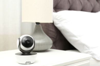 Baby camera on table in bedroom, space for text. Video nanny