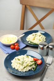 Photo of Delicious risotto with asparagus on grey table