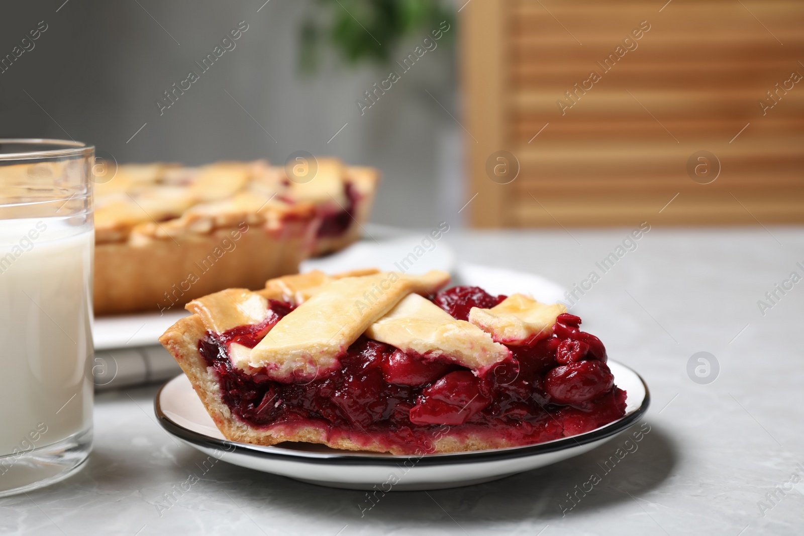 Photo of Piece of delicious fresh cherry pie on light grey marble table, closeup