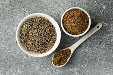 Photo of Caraway (Persian cumin) seeds and powder on light gray textured table, flat lay