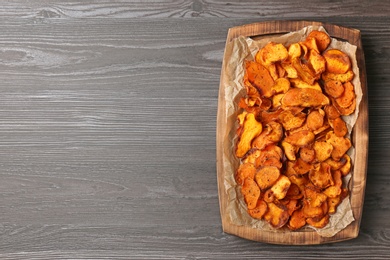 Tray with sweet potato chips on wooden table, top view. Space for text