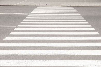 Photo of White pedestrian crossing on empty city street