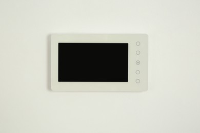 Photo of Modern video intercom hanging on white wall