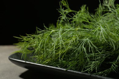 Photo of Fresh green dill on grey table, closeup