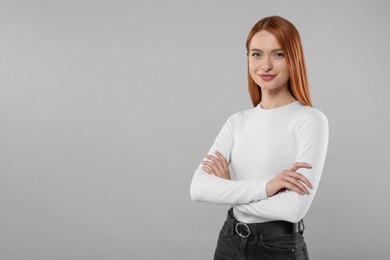 Portrait of beautiful young woman on light gray background, space for text