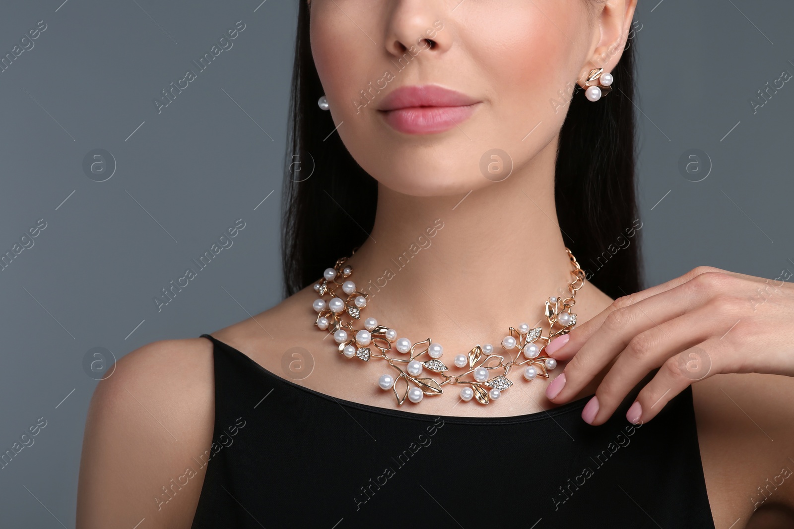 Photo of Young woman with elegant jewelry on dark grey background, closeup