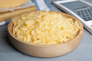 Photo of Tasty grated cheese on light grey wooden table