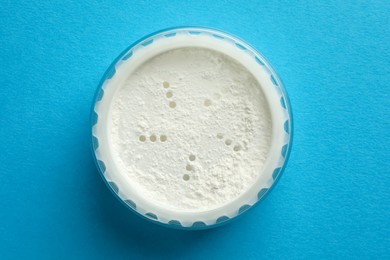 Photo of Rice loose face powder on light blue background. Makeup product