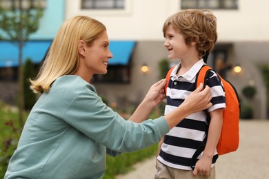 Photo of Happy mother and son near kindergarten outdoors