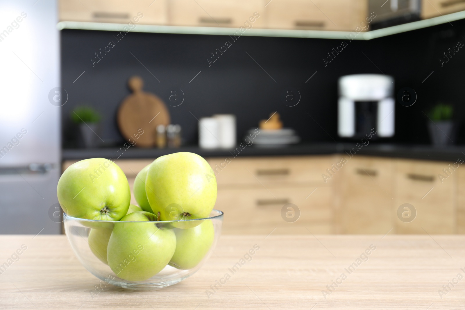 Photo of Fresh green apples on wooden table in kitchen. Space for text