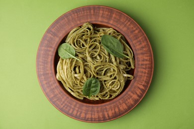 Photo of Tasty pasta with spinach on green table, top view