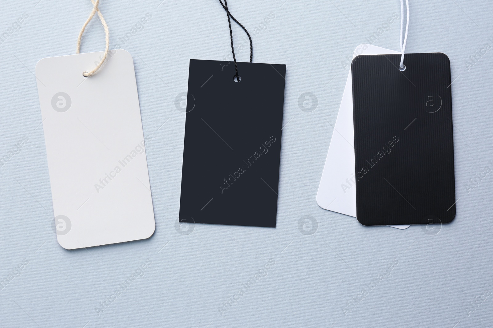 Photo of Set of different tags with space for text on light grey background, flat lay