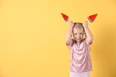 Cute little girl with candies on color background. Space for text