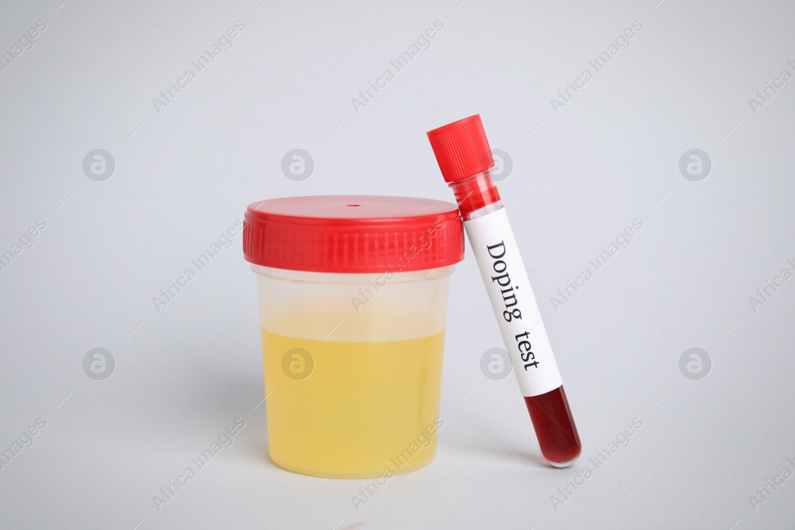 Photo of Jar and test tube with samples on light grey background. Doping control