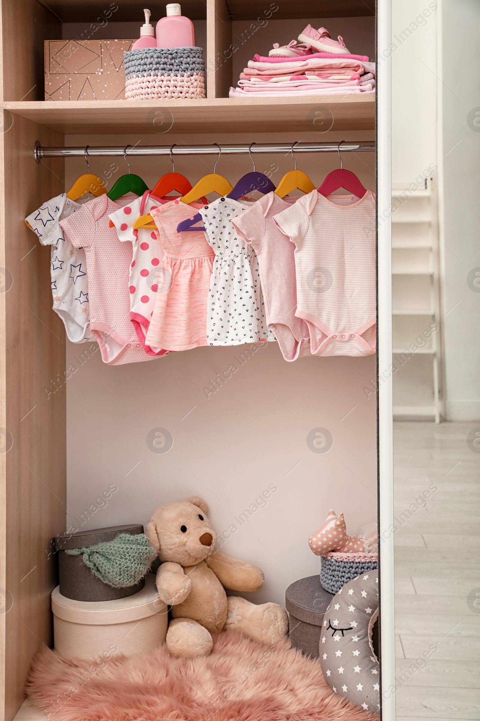 Photo of Wardrobe with cute baby clothes and toys