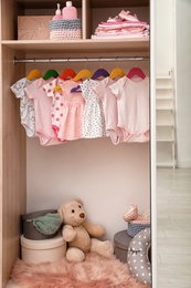 Photo of Wardrobe with cute baby clothes and toys