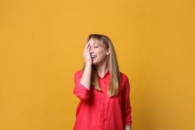 Photo of Beautiful young woman laughing on yellow background. Funny joke