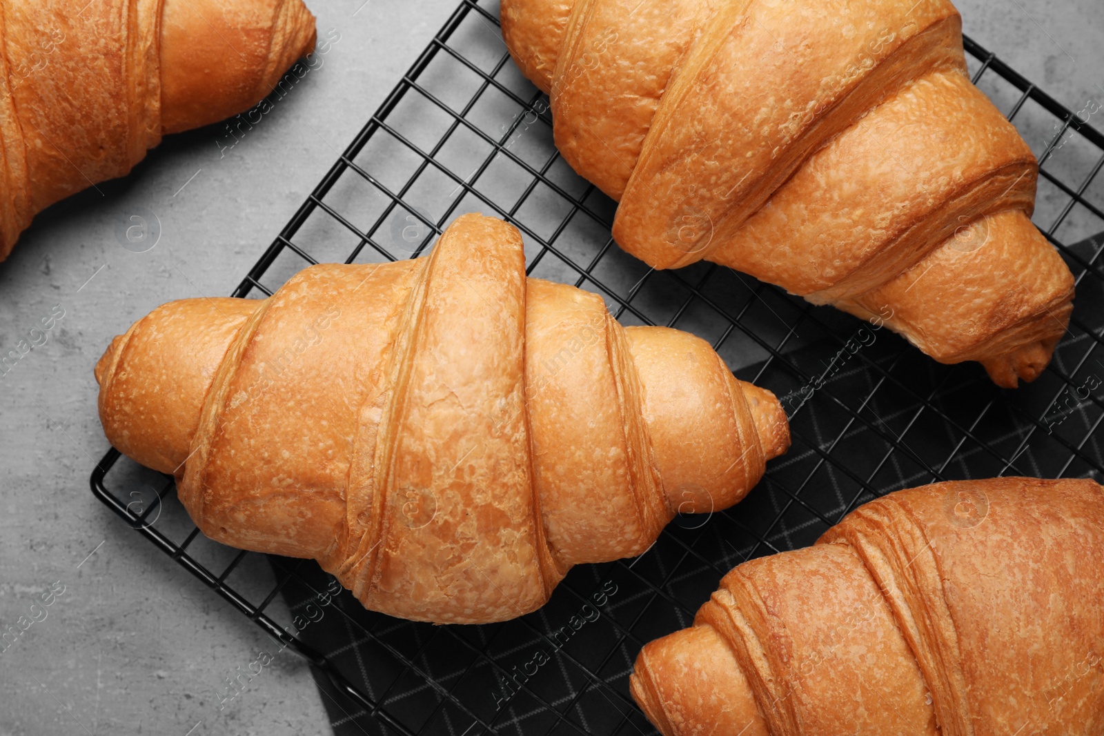 Photo of Tasty fresh croissants on light grey table, flat lay