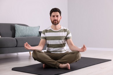 Photo of Man meditating at home. Harmony and zen