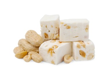 Photo of Pieces of delicious nougat and nuts on white background