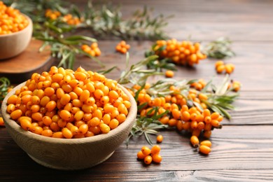 Photo of Fresh ripe sea buckthorn on wooden table. Space for text