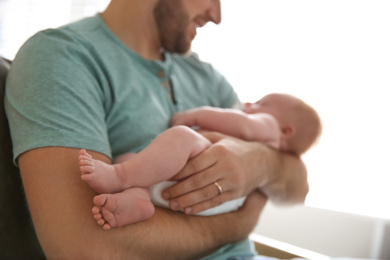 Father with his newborn son at home, closeup