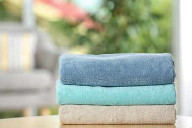 Stack of folded clean soft towels on table indoors