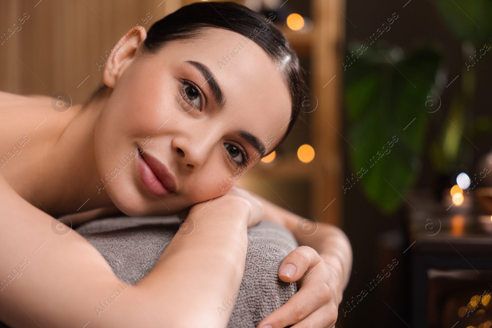 Photo of Spa therapy. Beautiful young woman lying on massage table in salon, space for text