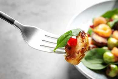 Fork with warm Brussels sprouts salad over table, closeup