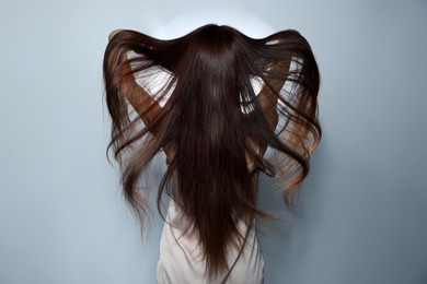 Photo of Fashion model with strong healthy hair posing in studio, back view