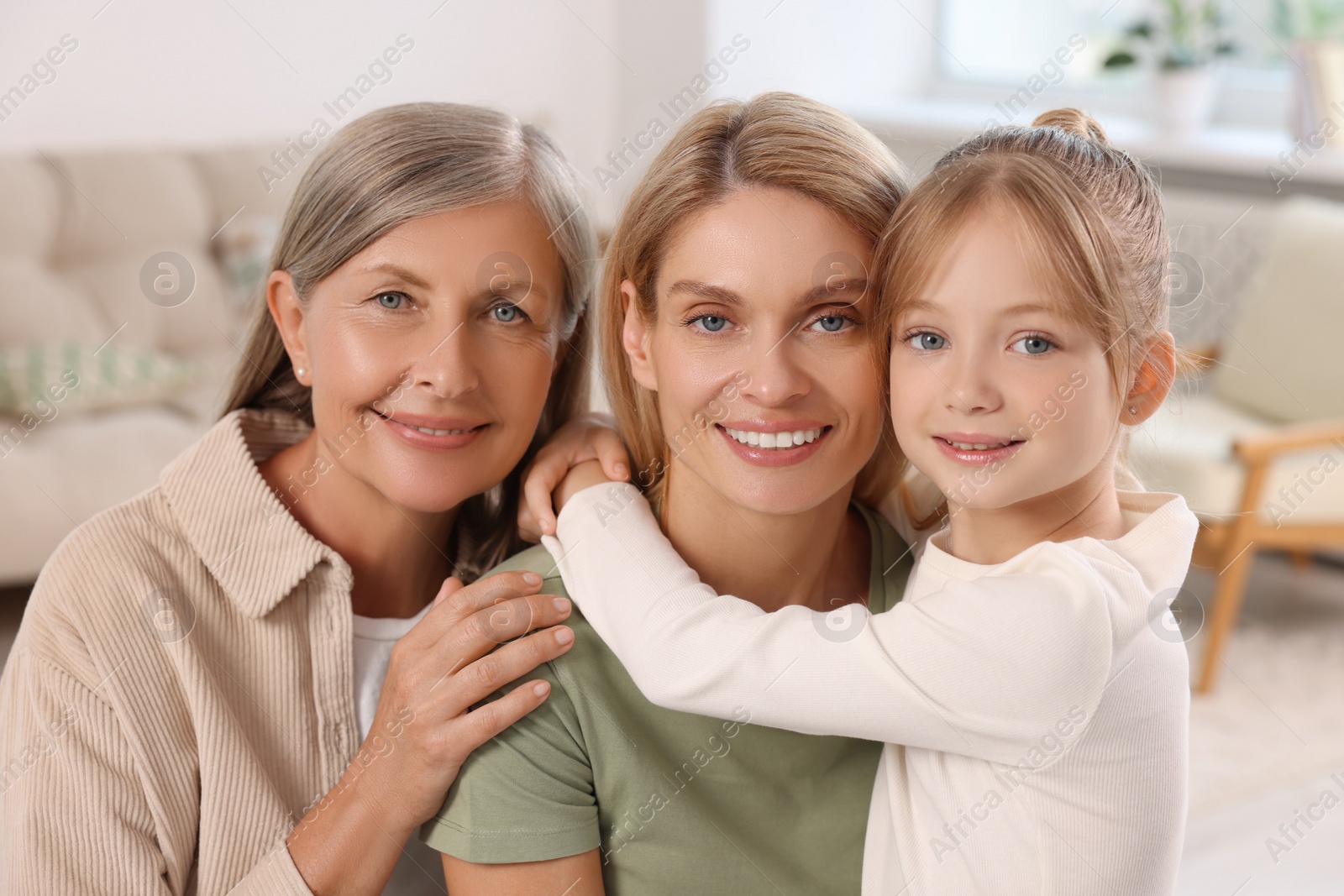 Photo of Three generations. Happy grandmother, her daughter and granddaughter at home