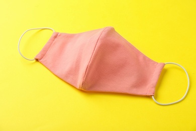 Photo of Homemade protective face mask on yellow background