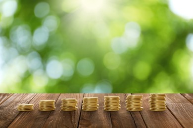 Image of Stacked coins on wooden table against blurred background. Investment concept