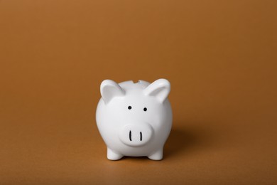 Photo of Ceramic piggy bank on brown background. Financial savings