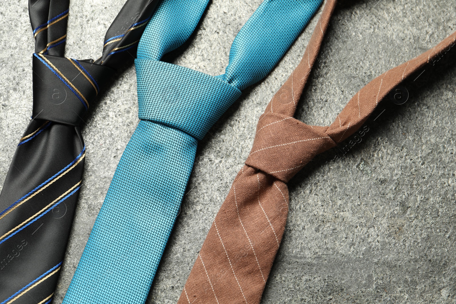 Photo of Different neckties on grey textured background, flat lay