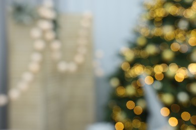Photo of Blurred view of Christmas tree and festive decor in room. Interior design