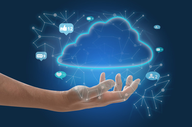 Image of Man demonstrating digital cloud with icons on blue background, closeup. Modern technology
