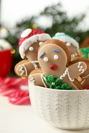 Photo of Delicious homemade Christmas cookies in bowl on white wooden table, closeup