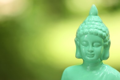 Photo of Decorative Buddha statue on blurred background, closeup. Space for text