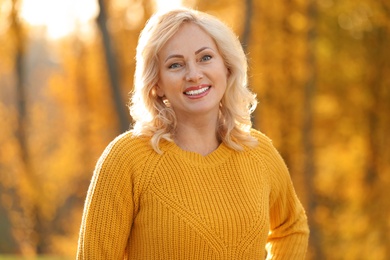 Portrait of happy mature woman in park on sunny day