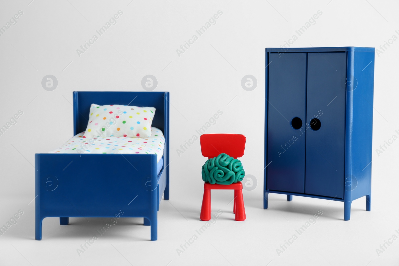 Photo of Brain made of plasticine on chair and mini furniture against white background