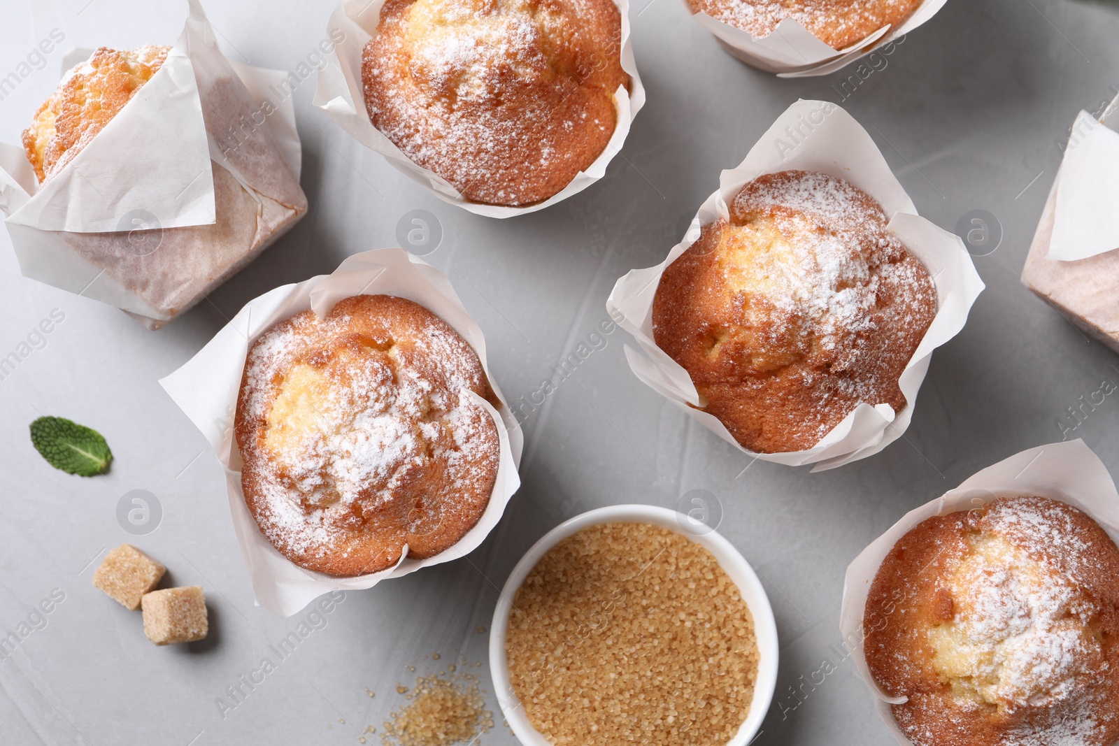 Photo of Delicious muffins on grey table, flat lay