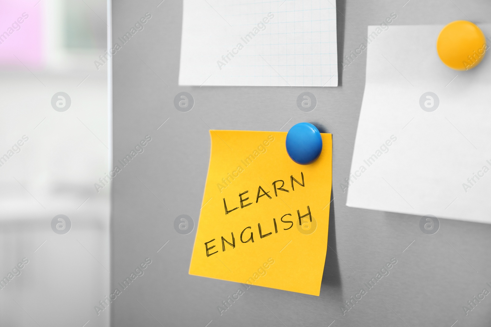 Image of Note with text Learn English on refrigerator door in kitchen