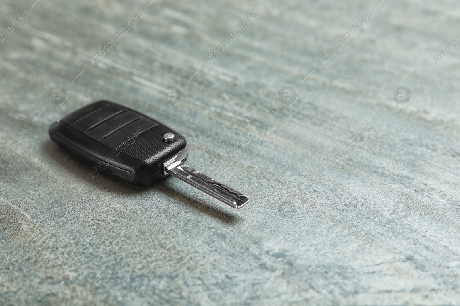 Photo of Car key on grey background. Space for text