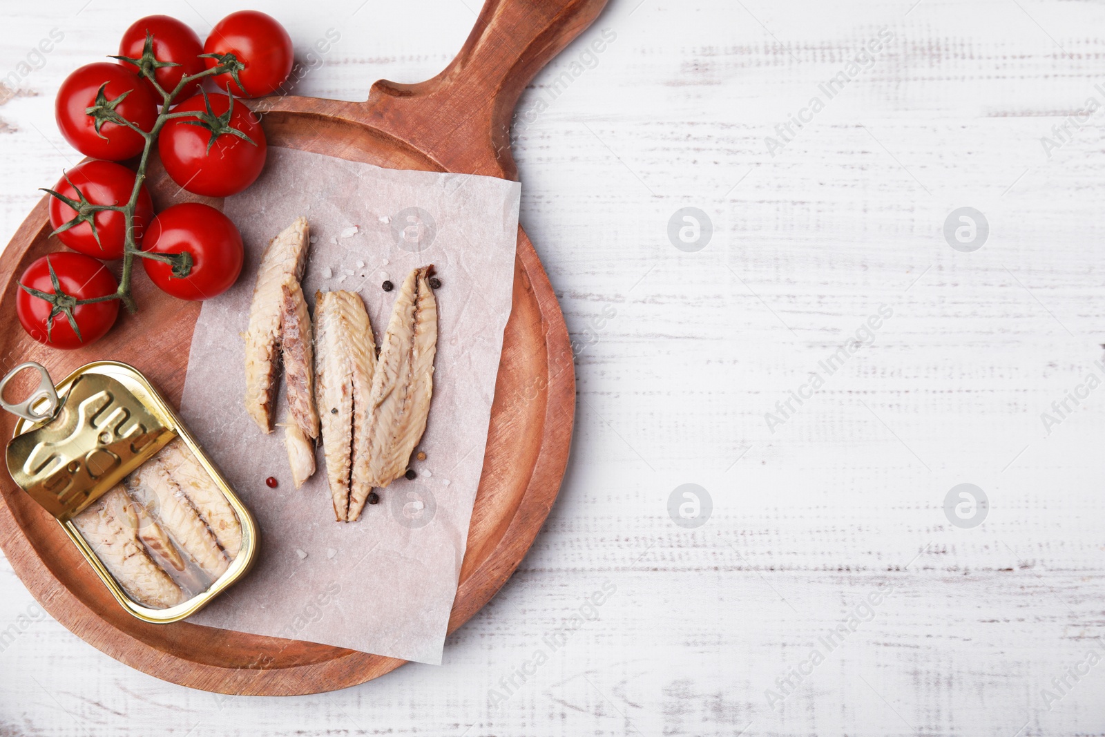 Photo of Delicious canned mackerel fillets and fresh tomatoes on white wooden table, top view. Space for text