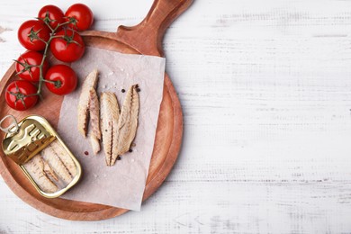 Photo of Delicious canned mackerel fillets and fresh tomatoes on white wooden table, top view. Space for text