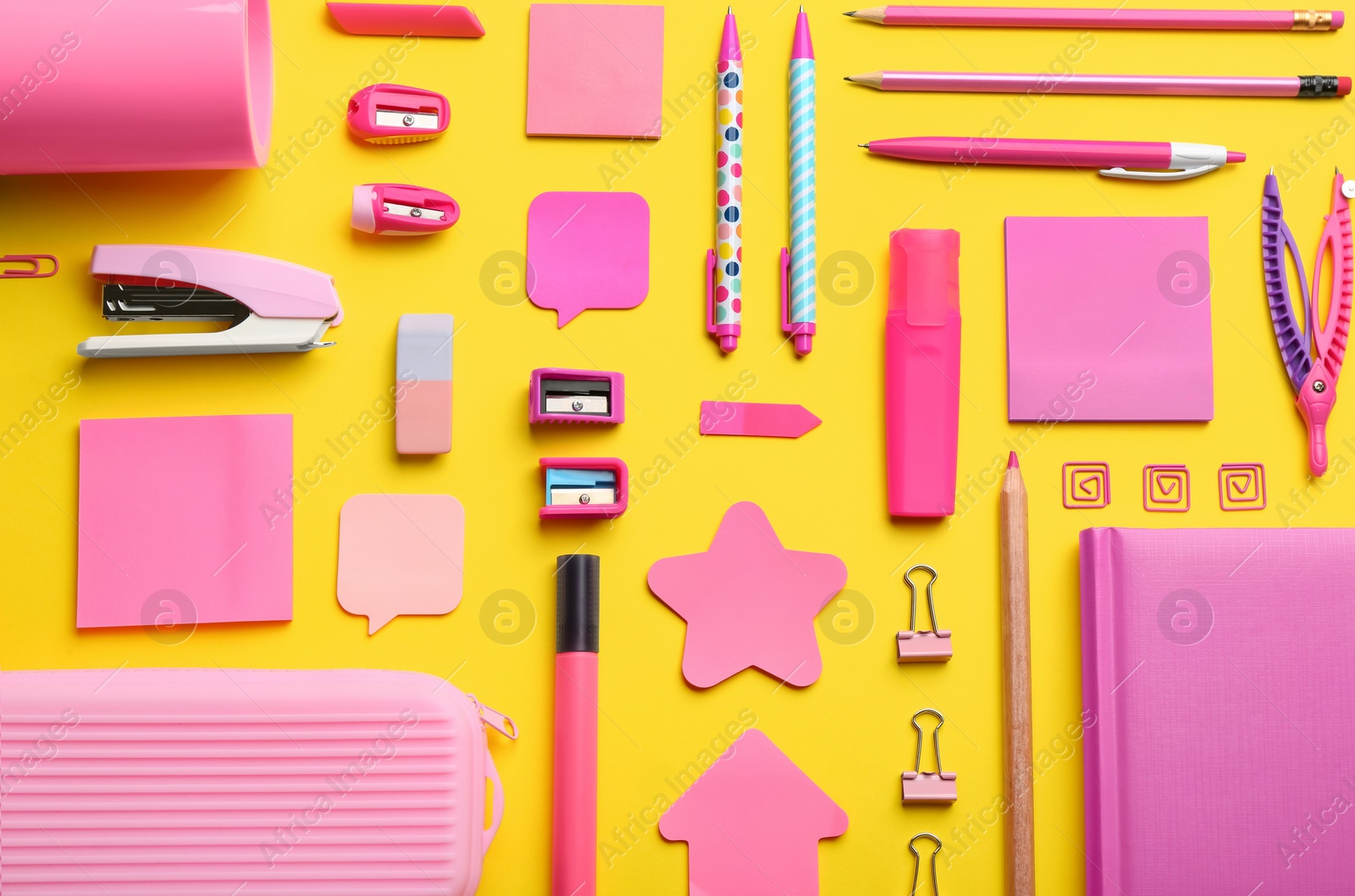 Photo of Flat lay composition with pink school stationery on yellow background. Back to school